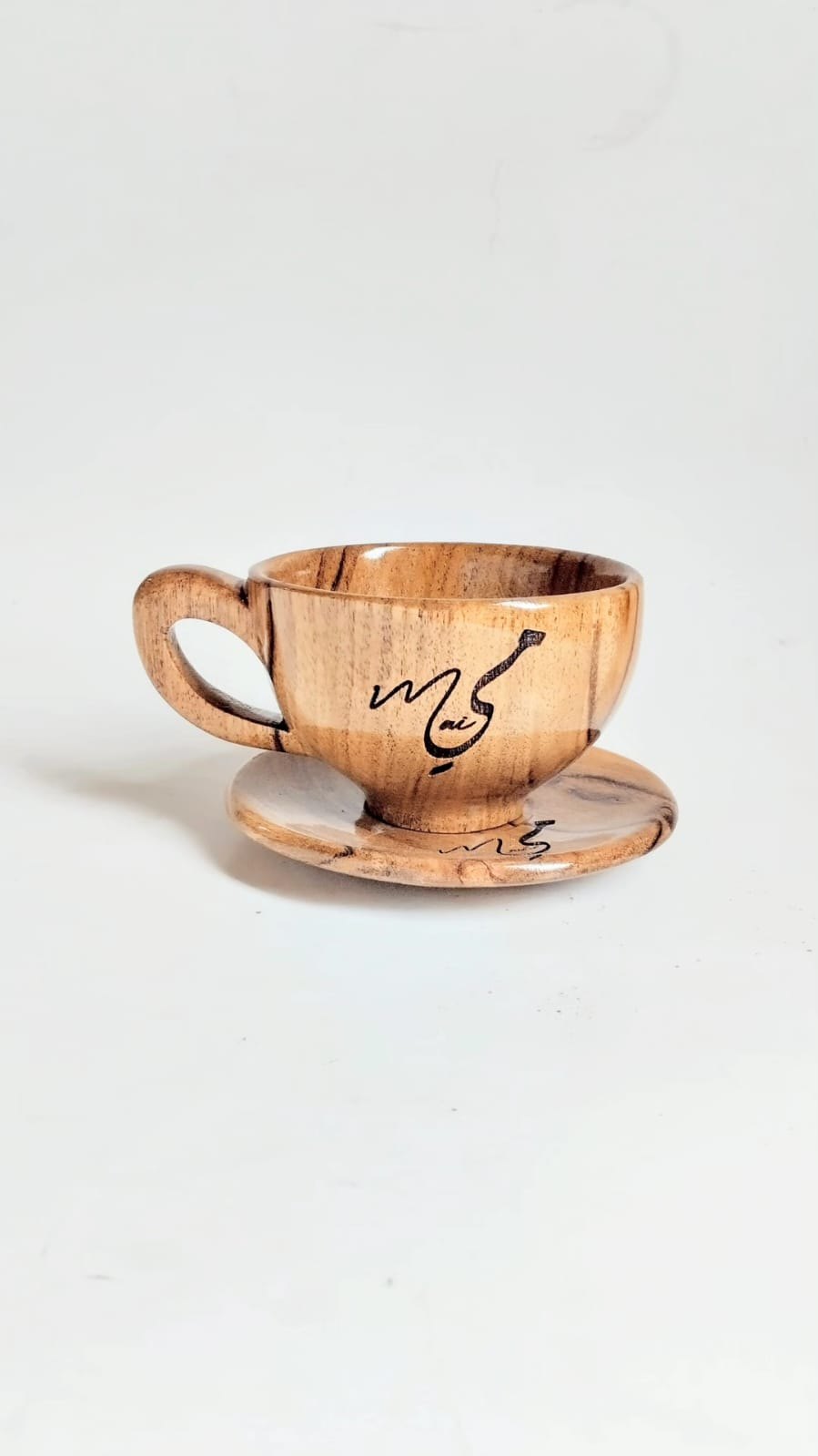 A cup and saucer engraved with Arabic calligraphy